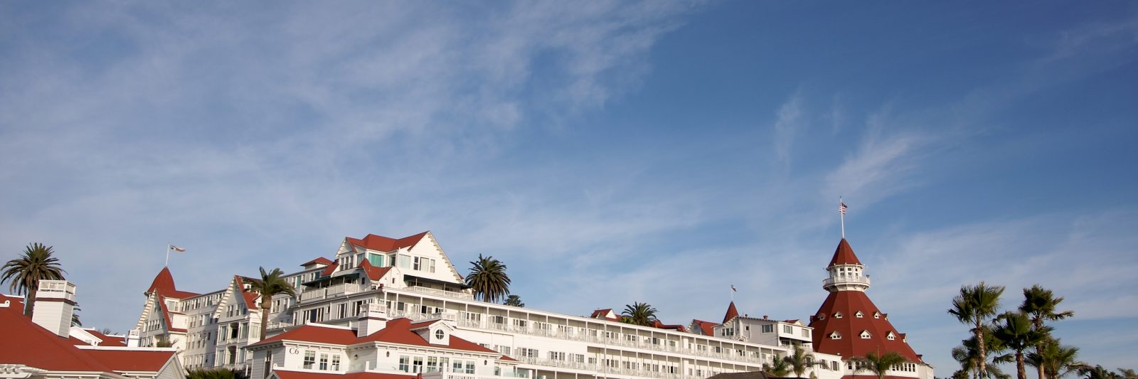 White and red building lining the beach as people check in and out