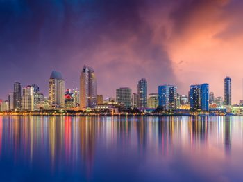 San Diego Skyline reflecting in the water at sunset with purple and pink sky