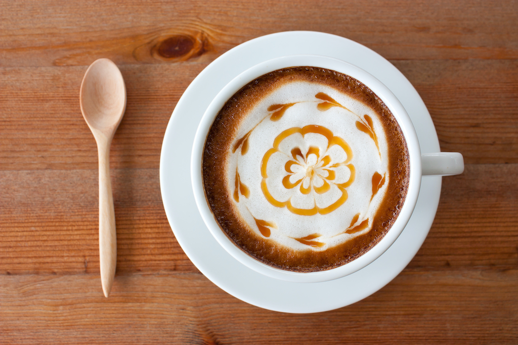 hot milk art coffee on wooden table , Vintage latte art coffee
