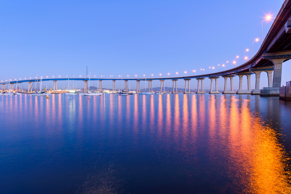 A close-up dusk view of Coronado Bridge, winding over calm San Diego Bay, at San Diego, California, USA.