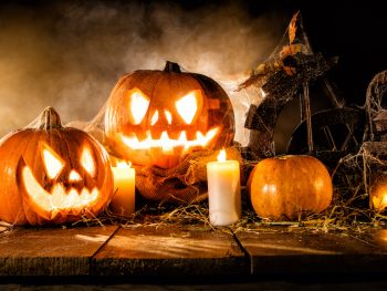 Scary halloween pumpkins on wooden planks. Empty space for text