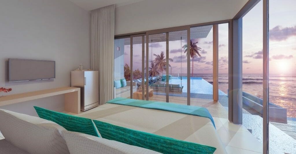 Mid-century modern furnished living room with large window front looking out to an infinity pool and the ocean