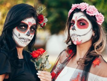 Two young women with sugar skull makeup - a typical Day of the Dead Traditions