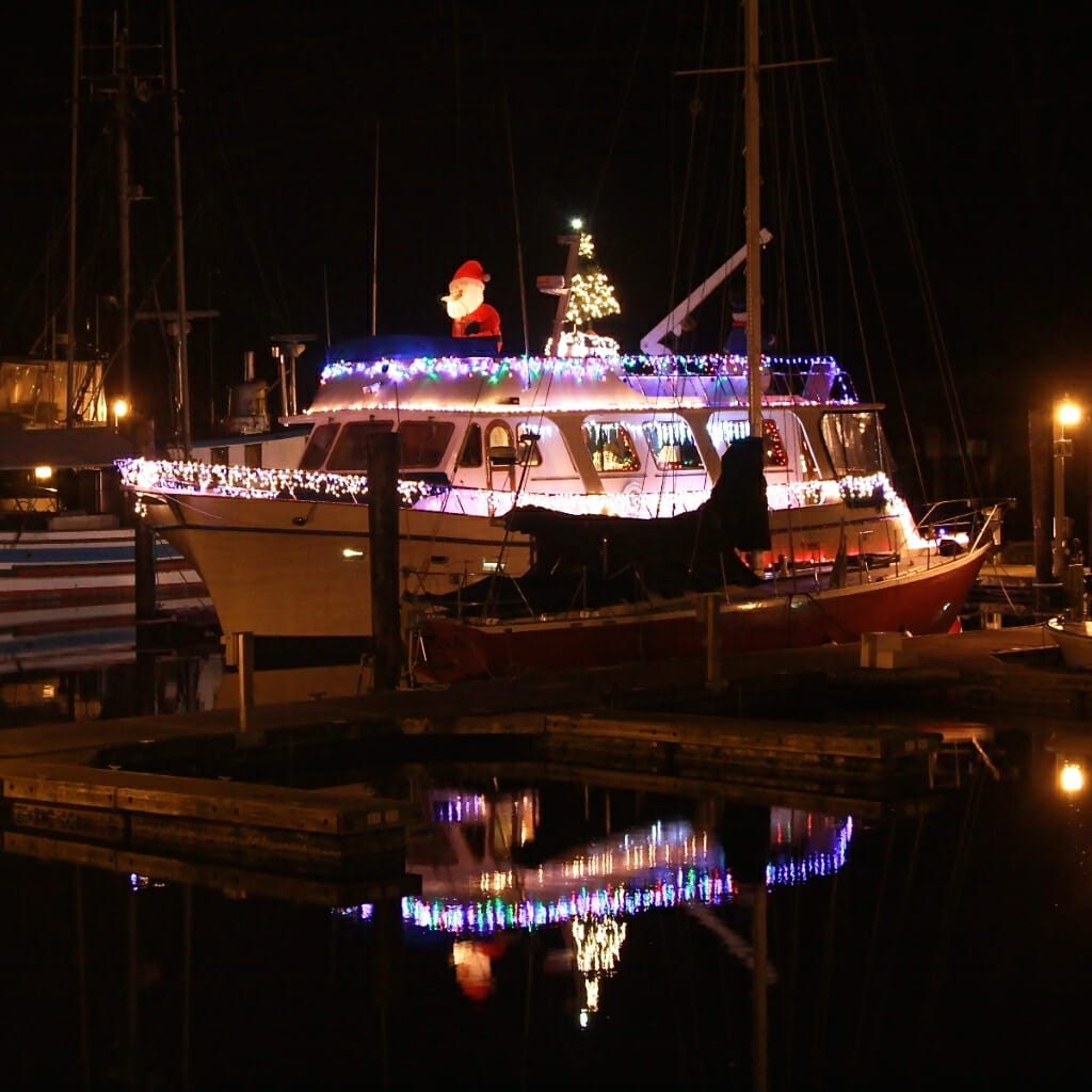 Boat on dock decorated with Christmas lights and Santa Claus