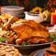 Festive holiday table with Turkey, side dishes, candles, orange candles - Thanksgiving dinner in San Diego