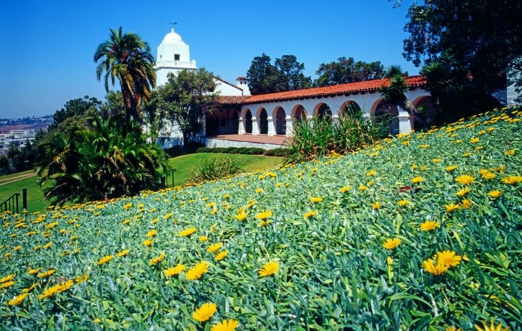White building that looks like a mission with arched covered walkways and bell tower - JUNÍPERO SERRA MUSEUM Old Town San Diego California