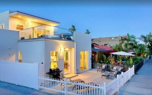 White modern two story house with white fence during dusk