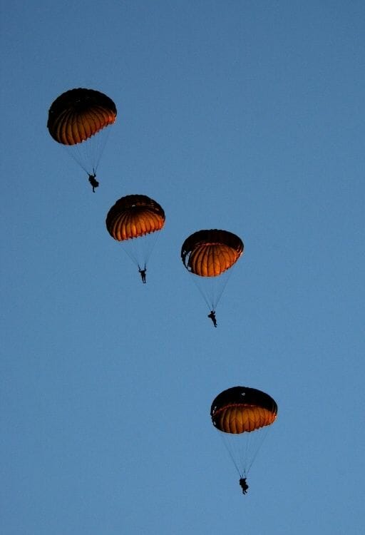 4 soldiers paragliding in formation