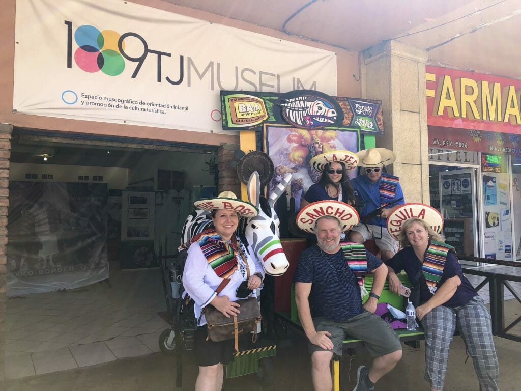 Group of people posing with a fake Tijuana donkey wearing sombreros
