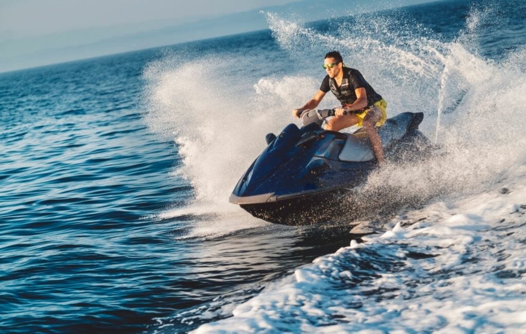man riding a jet ski on the ocean with waves and water splashing around him