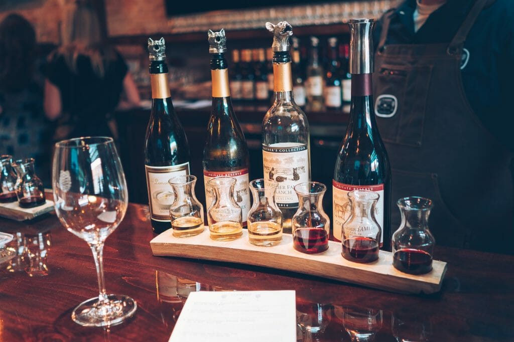 Coomber Wine Flight and wine bottles in the background