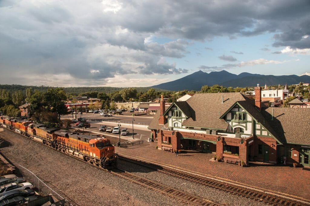 Aerial View of Flagstaff Train station / Flagstaff visitor center and a fright train passing by in front of it.