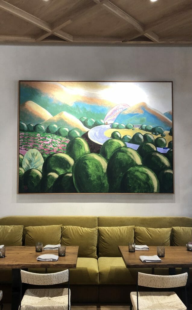 Painting and pea-green bench and tables at Valle Restaurant Oceanside