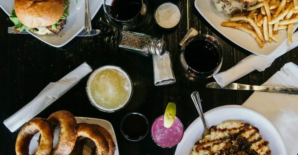 flatlay table shot with 4 main plates and drinks on a dark table