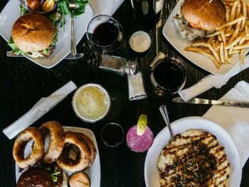 flatlay table shot with 4 main plates and drinks on a dark table