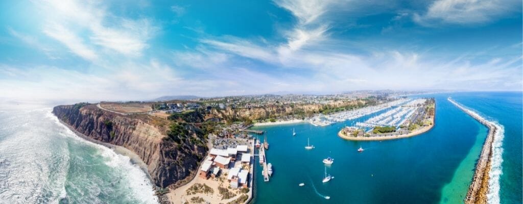 Dana Point Harbor Aerial View with Harbor on the right and cliffs on the coastline on the left