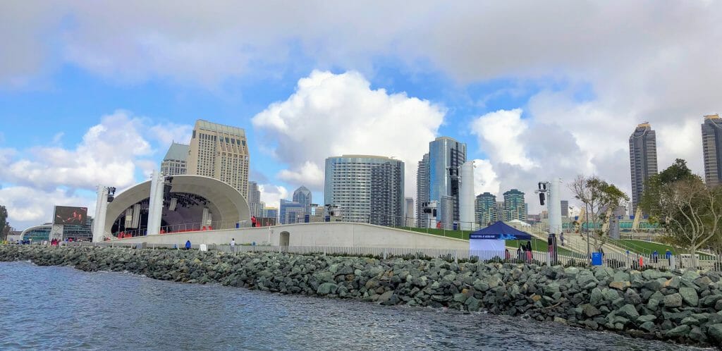 White shell-shaped concert hall on the embarcadero in San Diego Bay with the San Diego Skyline in the Background - The Rady Shell Symphony San Diego