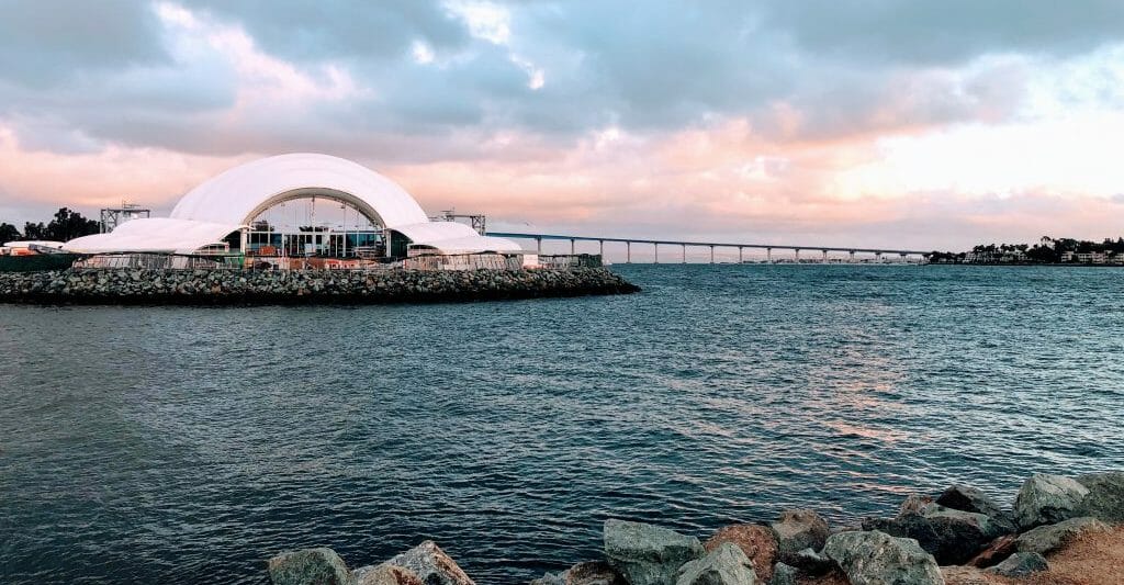 White shell-shaped concert hall on the embarcadero in San Diego Bay with the Coronado Bay Bridge in the Background - The Rady Shell Symphony San Diego