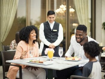 waiter attending a table with a young couple and young child