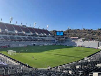 Soccer players practicing in large outdoor stadium on sunny day. Snapdragon Stadium San Diego.