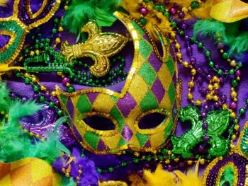 gold, purple, and green colored mardi gras mask, beads and feathers