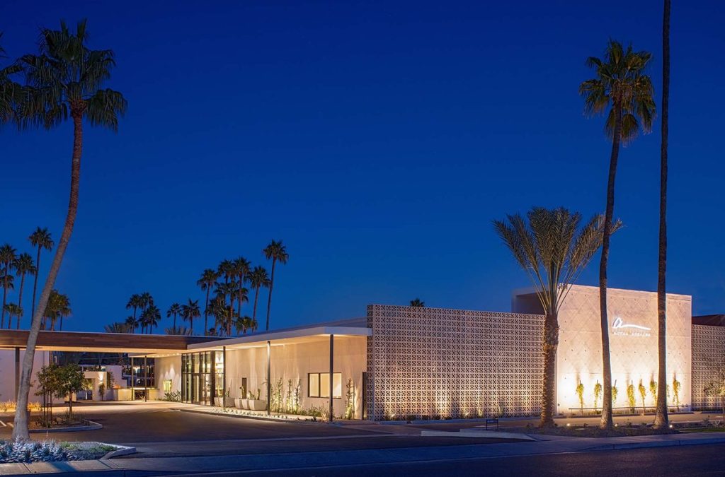 Exterior of the Hotel Adeline with palm trees during blue hour