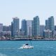 Sail boats on blue water of San Diego Bay with expansive downtown San Diego skyline in background on sunny day. September in San Diego.