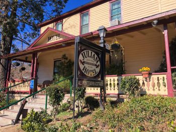 Entrance to porch and yellow facade of the Julian Gold Rush Hotel - Where to stay in Julian CA