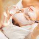 Close up of woman in white towels receiving facial from technician at spa. San Diego Spas.