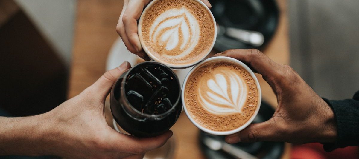 Group of people cheers-ing coffee cups. Coffee Shops San Diego.