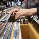 Person browsing through vinyls and CDs in record store. San Diego Record Stores.