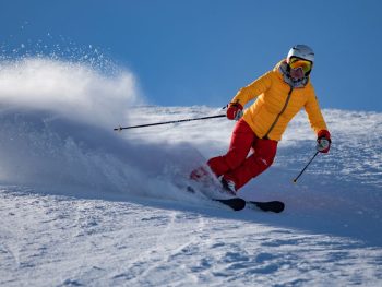 person on skies shredding down the mountain