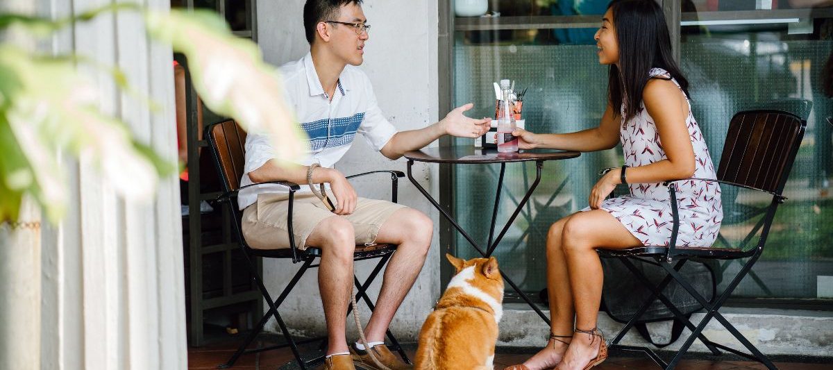 couple and corgi dog sitting at a Dog friendly restaurants San Diego