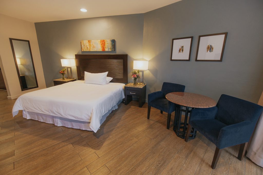 Hotel guest room with large bed and spacious seating area. Ensenada hotels, Ensenada, Mexico.
