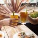 Two people cheers-ing beers on outdoor patio at restaurant. The Duck Dive, Pacific Beach Bars.