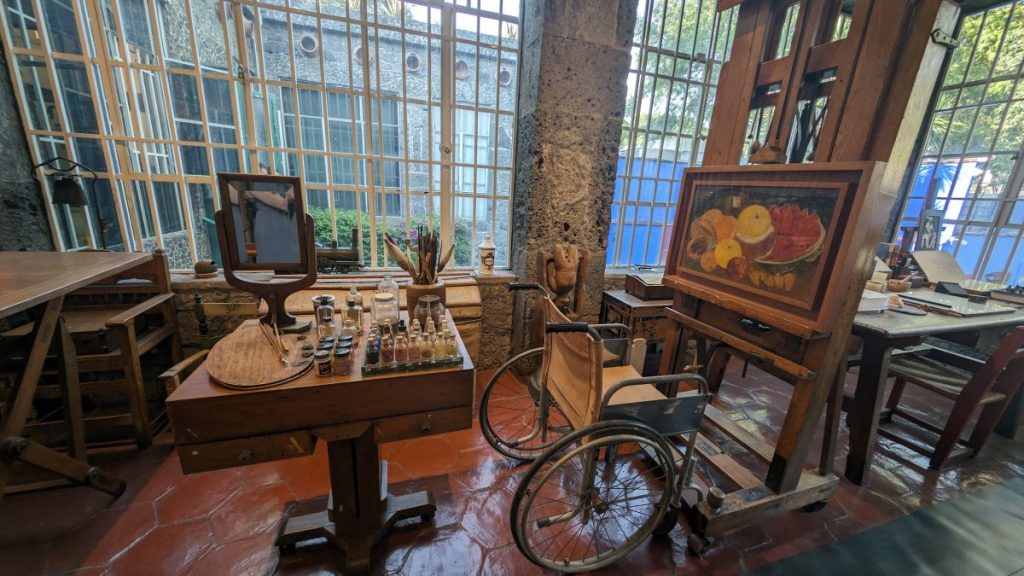 Frida Kahlo&rsquo;s art studio with canvas, table with paints and her wheelchair