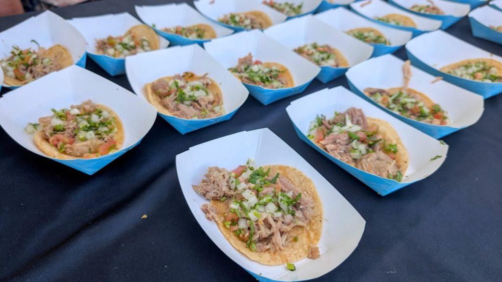 rows of carnitas tacos on table