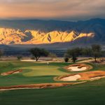 Rams Hill Golf Club with mountains in the background lid up by sun; Photo Credit: Troy Knight