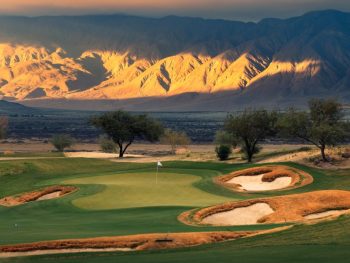 Rams Hill Golf Club with mountains in the background lid up by sun; Photo Credit: Troy Knight