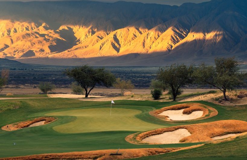Rams Hill Golf Club with mountains in the background lid up by sun; Photo Credit: Troy Knight