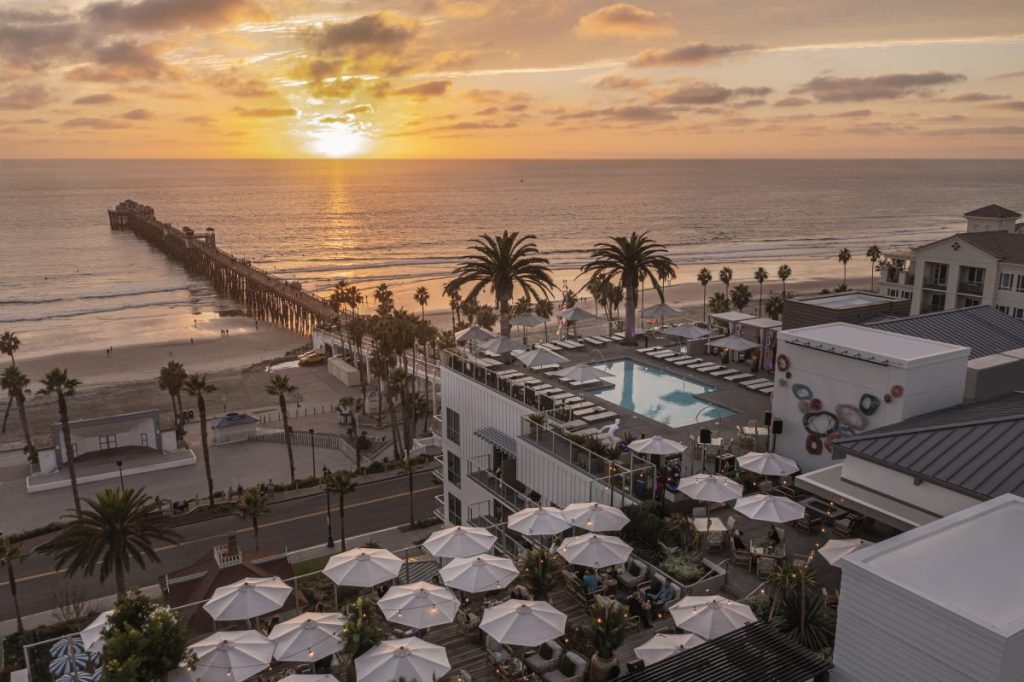 Aerial view of Mission Pacific Hotel and pool and Oceanside pier at sunset