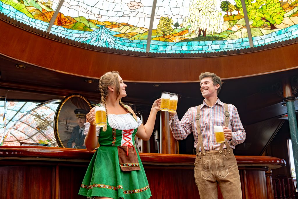 people dressed in German dress with beer glasses 