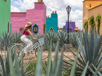 Woman riding bike in front of Casa trujillo in Tepatitlán